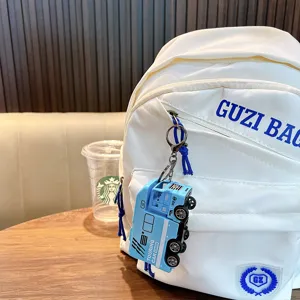 Μπλε μπρελόκ αυτοκινούμενου τροχόσπιτου από κράμα σε ένα λευκό σακίδιο πλάτης