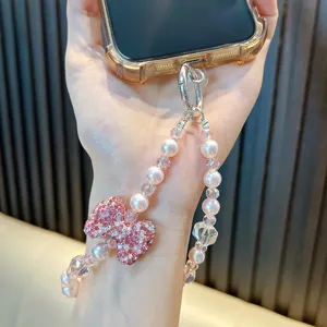 Elegant rhinestone bow phone charm with pink pearls and crystal beads for wrist.