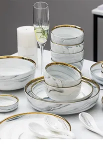 Detailansicht von einem luxuriösem Marmor-Keramikgeschirr-Set mit elegantem Goldrand
