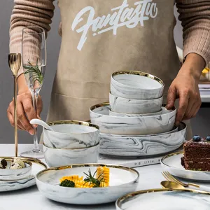Elegantes Marmor-Keramik-Geschirrset mit luxuriösem Goldrand für das Abendessen.