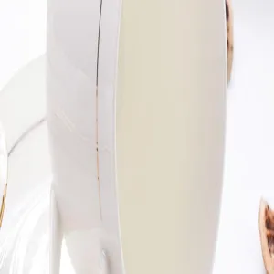 Primer plano de una taza de porcelana blanca de alta calidad con borde dorado elegante.