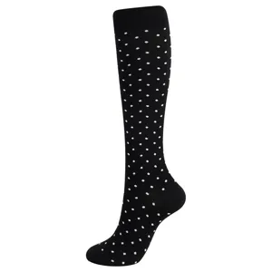 Vue détaillée de la chaussette de compression noire à pois blancs montant au genou