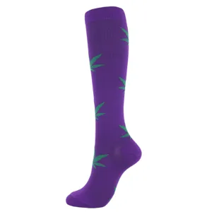 Purple knee-high compression sock with green leaf patterns on a white background