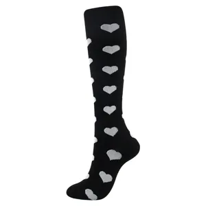 Gros plan sur des chaussettes de compression noires à motif cœur blanc genou