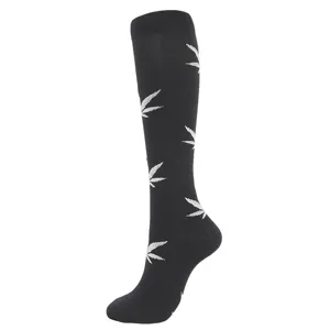 Side view detail of black compression knee-high socks with stylish white leaf pattern