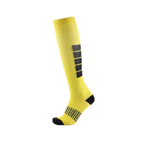Detailed view of yellow long compression sock with black striped calf and foot accents