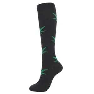 Black compression knee-high sock with green leaf patterns shown on white background