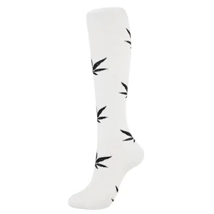 Close-up of white compression knee-high sock with black leaf pattern print