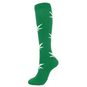 Green knee-high compression socks with white cannabis leaf pattern for sports and cycling