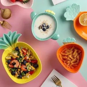 Vibrant fruit-shaped ceramic dipping bowls featuring pineapple and carrot designs