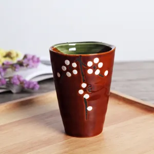 Vista detallada de una taza de té de cerámica japonesa con diseño de flores de ciruelo