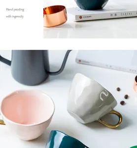 Detail showing the irregular texture and gold handle of a pink ceramic coffee mug