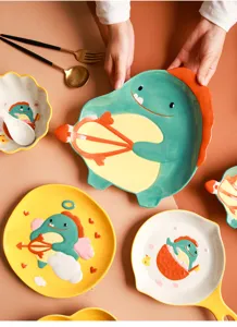 Detailansicht süßer Keramikteller und Schalen im Dinosaurier-Design in bunten Farben