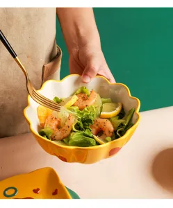 Gelbe Keramikschüssel mit gewelltem Rand und Garnelensalat in einer Küchenumgebung