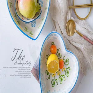 Detailed macro view of a heart-shaped ceramic salad bowl with delicate hand-painted floral patterns