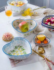 Macro view of patterned ceramic heart-shaped bowls with colorful floral designs