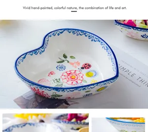 Detailed view of hand-painted floral and nature patterns inside a heart-shaped ceramic bowl