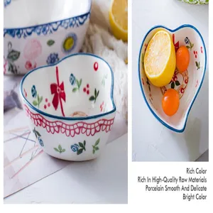 Detail showing smooth porcelain and colorful hand-painted patterns on heart-shaped bowl