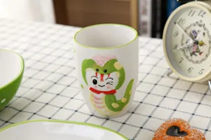 Gros plan d'un mug en céramique avec serpent de dessin animé, vaisselle japonaise.