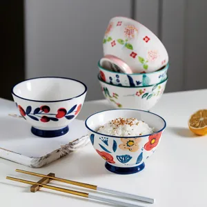 Hand-painted Japanese ceramic rice bowls with colorful floral and berry patterns.
