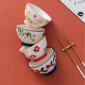 Four Japanese style hand-painted ceramic rice bowls with colorful floral patterns and high feet