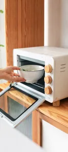 Gedetailleerd zicht op een witte keramische kom met verticale strepen die in de oven wordt geplaatst