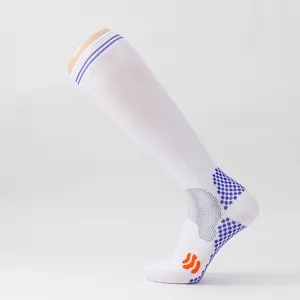 Detailansicht weißer Kompressions-Fußballsocken mit blauen rutschfesten Noppen.