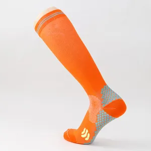 Nahaufnahme von orangen Sport-Kompressionssocken mit verstärkter Ferse und Anti-Rutsch-Struktur.