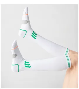 Gedetailleerd overzicht van witte sportcompressiekousen met ademend mesh en groene accenten