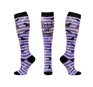 Vue détaillée de chaussettes de compression Halloween à rayures mauves et motif Trick or Treat