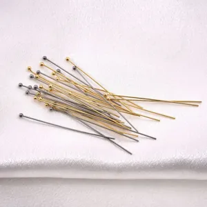 Close-up showing textured gold and silver stainless steel ball head pins for jewelry.