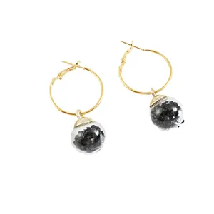 Elegant gold hoop earrings with clear glass globes filled with black crushed stones.