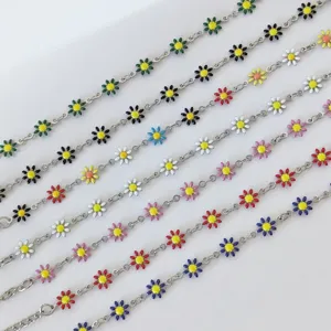 Primo piano di ciondoli a margherita in smalto colorato su braccialetti a catena in acciaio