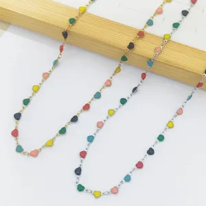 Detailed view of colorful enamel heart charms on stainless steel link chain necklaces
