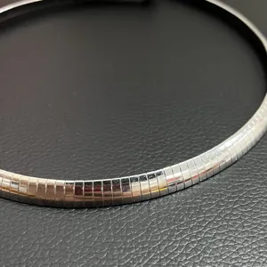 Vue détaillée d'un collier ras du cou segmenté en acier inoxydable poli brillant