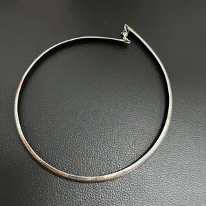 Vue détaillée d'un collier ras du cou Omega en acier inoxydable sur fond sombre