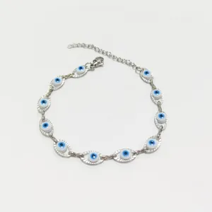 Dettaglio di un bracciale in acciaio inossidabile con malocchio blu su sfondo bianco.