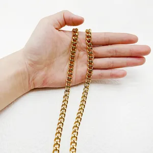 Collier chaîne gourmette en acier inoxydable doré poli tenu en main pour l'échelle
