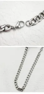 Dettaglio macro di collana a catena NK in acciaio argento con robusta chiusura a moschettone