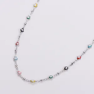 Detail view of vibrant colorful hamsa hand charms on a sleek stainless steel necklace.