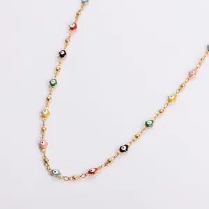 Close-up of colorful Hamsa palm charms and gold beads on a minimalist stainless steel necklace