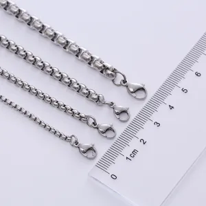 Polished silver box chains in four different thicknesses shown with a scale ruler for sizing