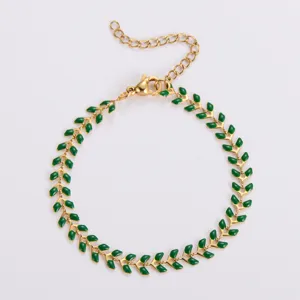 Elegante bracciale a spina di pesce in acciaio dorato con dettagli in smalto verde