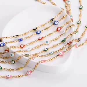 Close-up of colorful Hamsa evil eye charms on a gold-plated stainless steel chain.
