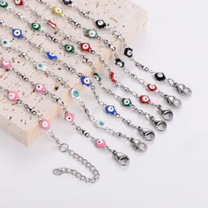Assorted stainless steel necklaces with colorful Hamsa hand charms on stone display