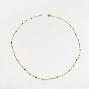 Detailed macro view of a gold-plated chain necklace with colorful rainbow enamel beads.