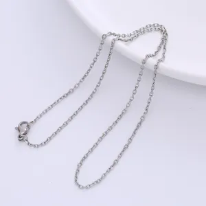 Close-up of minimalist silver faceted cross chain necklace with lobster clasp