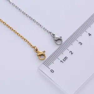 Detailed view of gold and silver cross chain necklaces with lobster clasps and ruler