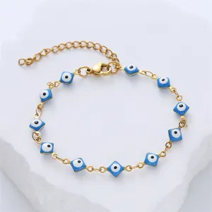 Detailed view of the golden stainless steel bracelet with blue evil eye enamel charms.