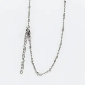 Detailed close-up view of a stainless steel beaded cross chain with lobster clasp